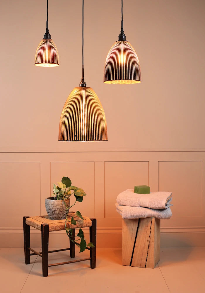 Cluster of 3 large black and gold ribbed glass bathroom pendant lights with plant and towels 