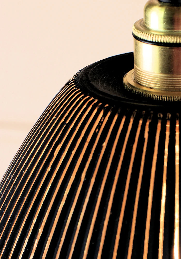 Close up of black and gold glass pendant light shade with brushed brass lamp holder