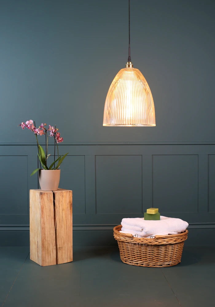 Large bell shaped ribbed glass bathroom pendant light with pink flowers and basket with towels