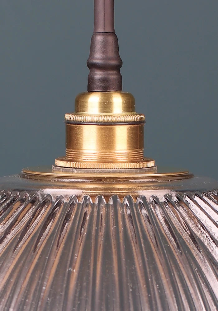 Close up of brushed brass lamp holder on large ribbed glass bathroom pendant light 