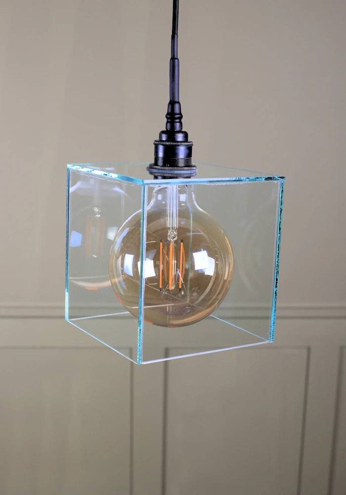 Square clear glass bathroom pendant light with antique bronze lamp holder and black fabric flex.