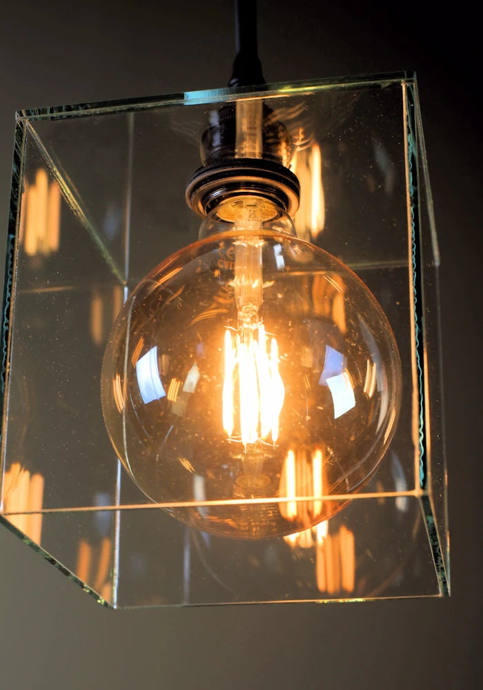 Close up of square clear glass bathroom pendant light with warm LED light bub