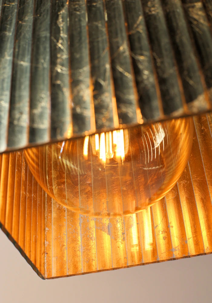 Close up image inside of large cube gold leaf bathroom pendant light.