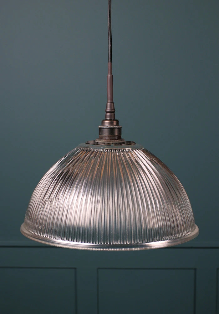 A large glass dome bathroom pendant light with antique bronze lamp holder and black fabric flex