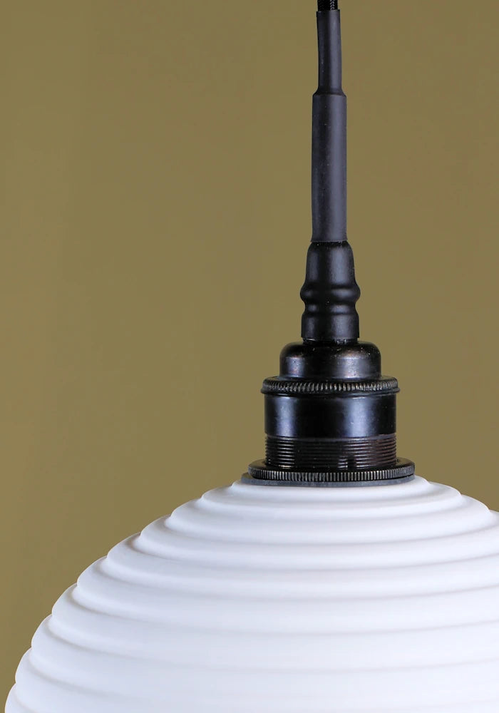 Optic porcelain bathroom pendant light with antique bronze lamp holder.