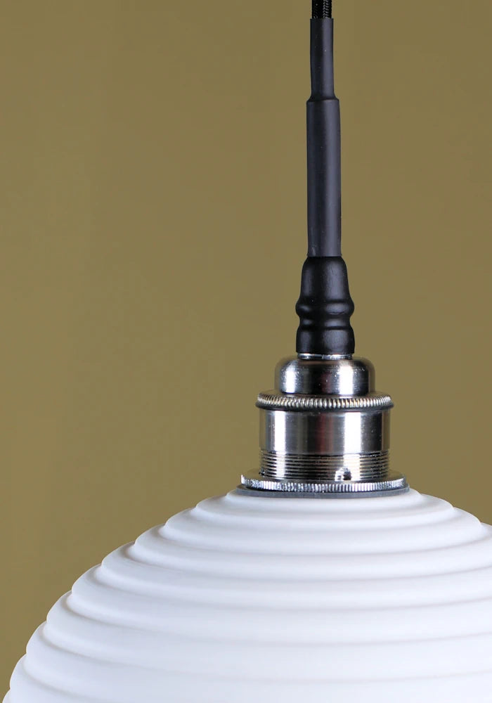 Optic porcelain bathroom pendant light with brushed nickel lamp holder.