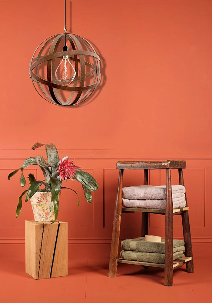 Orbital industrial style bathroom pendant light, plant and wooden stool with bath towels.