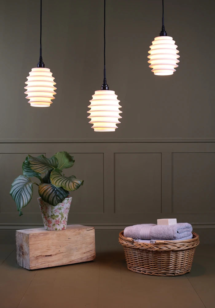 Concertina style porcelain cluster bathroom pendant light with plant and basket of bath towels 