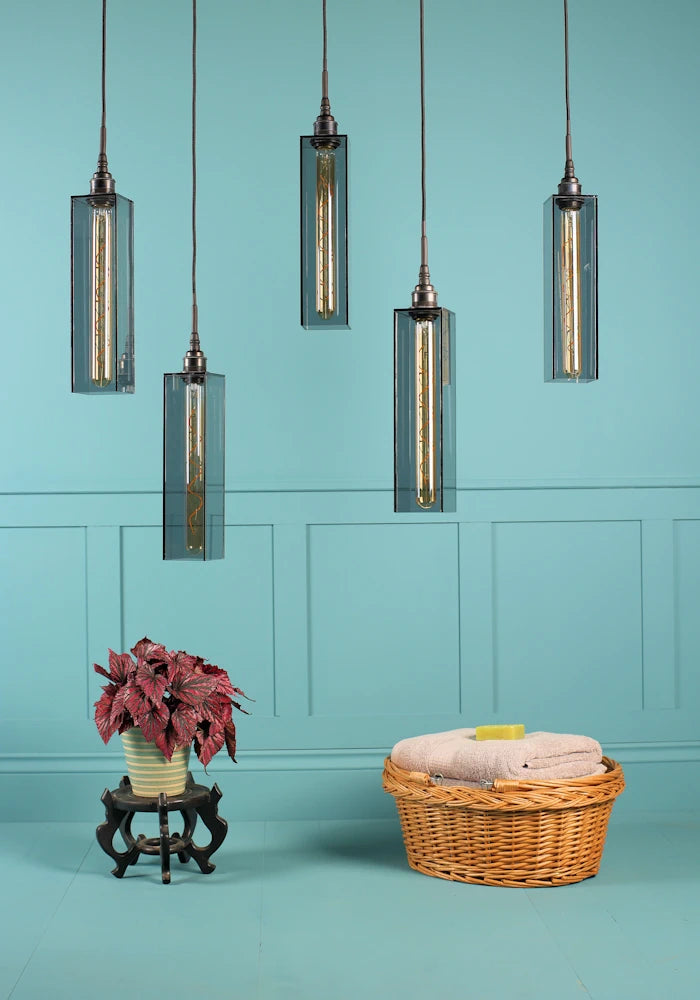 5 elongated rectangular smoked glass cluster bathroom pendant light switched off, plant and bath towels.