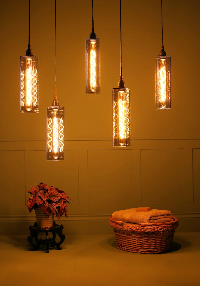 5 elongated rectangular smoked glass cluster bathroom pendant light casting shadows, plant and bath towels.