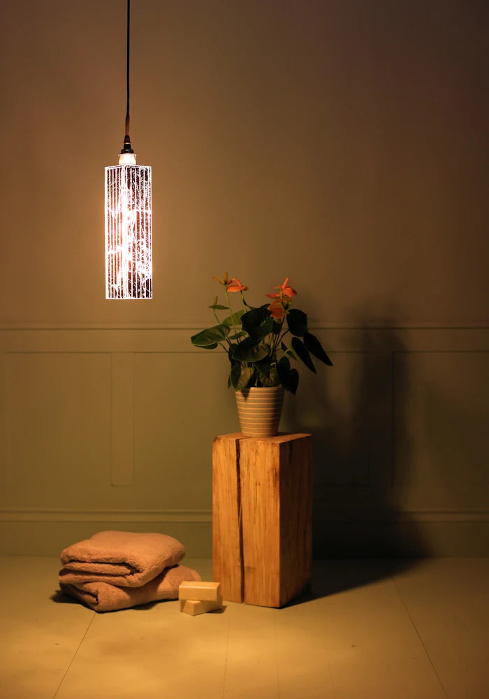 Long rectangular silver leaf bathroom pendant light with bath towels and pot plant.