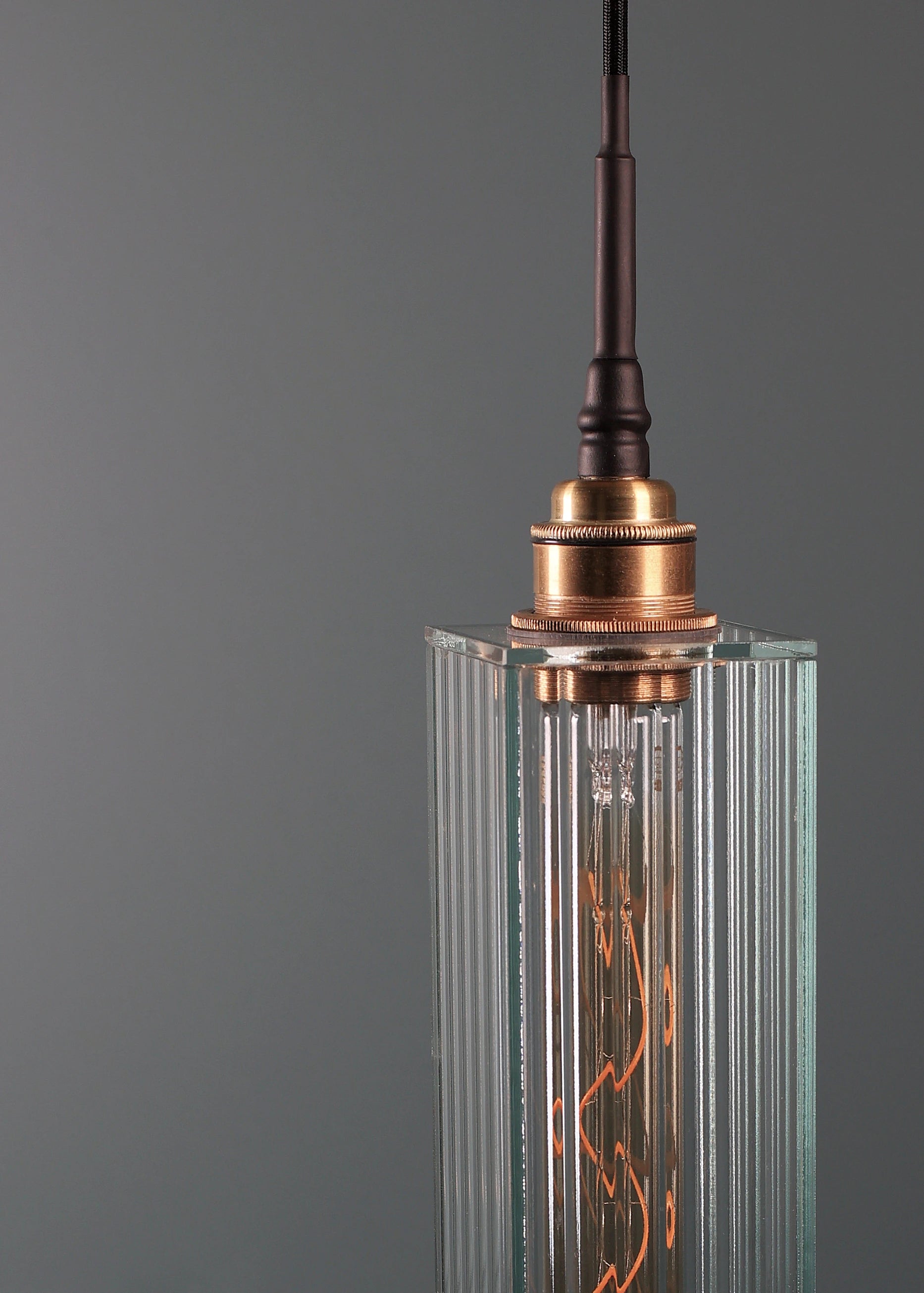 Long rectangular ribbed glass bathroom pendant light with brushed brass lamp holder.