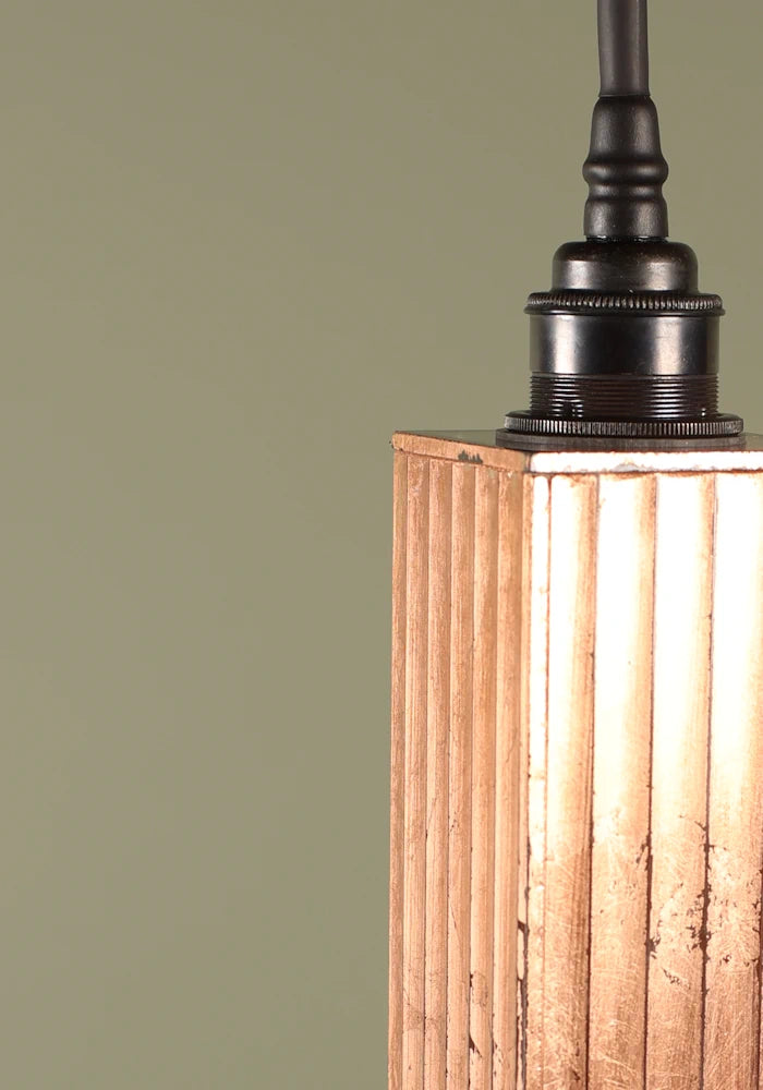 Close up of elongated copper leaf bathroom pendant light.