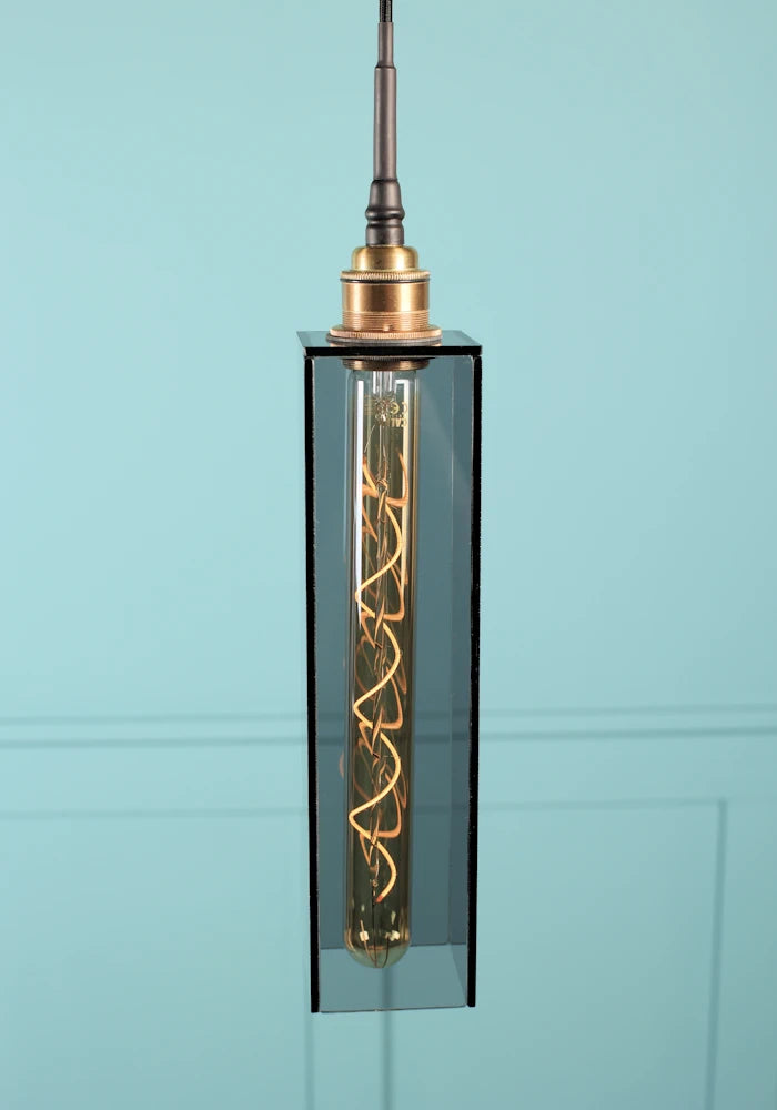 Elongated rectangular smoked glass bathroom pendant light with brushed brass lamp holder.